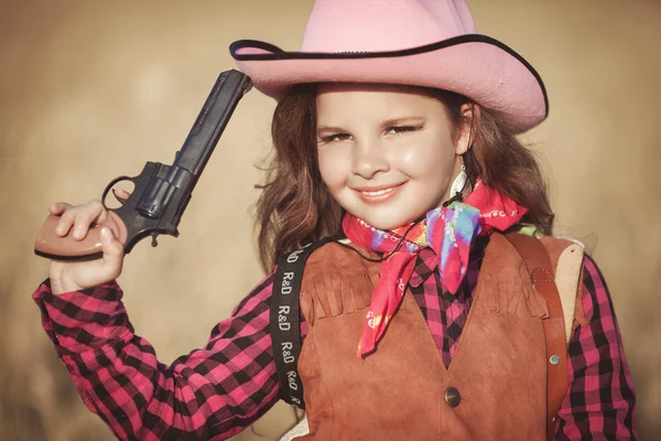 Cowboy meisje met pistool op gouden tarwe — Stockfoto