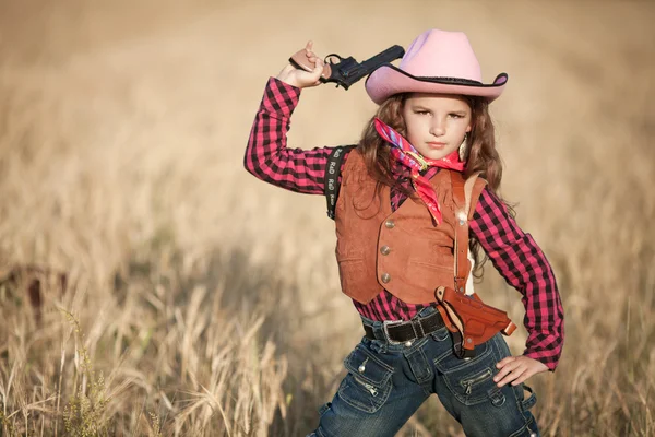 Cowboy girl with gun on golden wheat — Stock Photo, Image