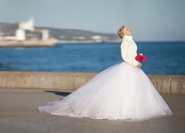 Novia en vestido de novia con ramo de rosas — Foto de Stock