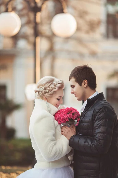 Bride and groom with roses bouquet — Stock Photo, Image