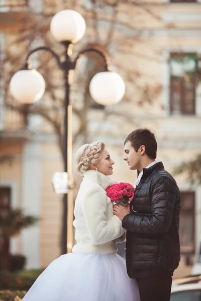 Braut und Bräutigam mit Rosenstrauß — Stockfoto