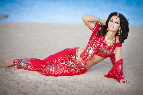 Mulher indiana bonita em vestido vermelho tradicional e jóias douradas ao ar livre — Fotografia de Stock