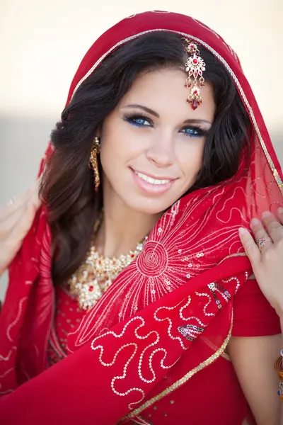 Schöne Indianerin in traditionellem roten Kleid und goldenem Schmuck im Freien — Stockfoto