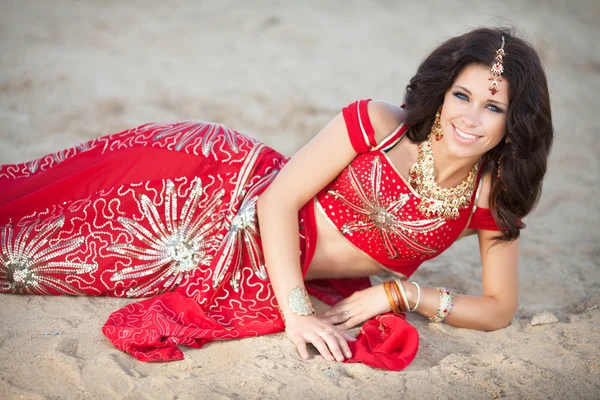 Gyönyörű indiai nő a hagyományos piros ruhában és arany ékszerek a szabadban — Stockfoto