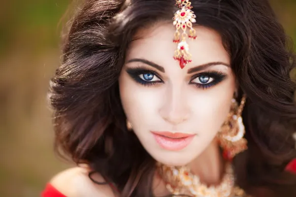 Hermosa mujer india en vestido rojo tradicional y joyas de oro al aire libre —  Fotos de Stock