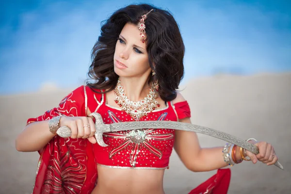 Beautiful Indian woman dancing with golden sword outdoors — Stock Photo, Image