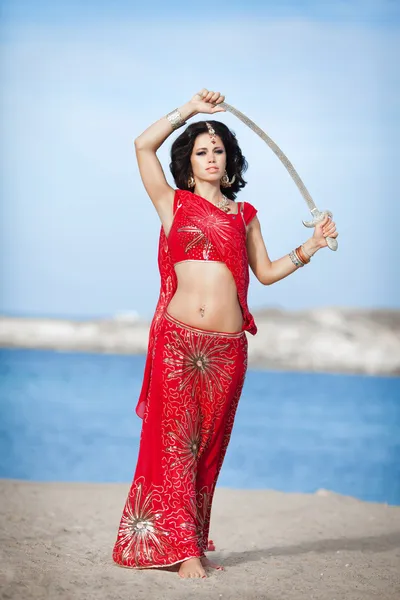 Beautiful Indian woman dancing with golden sword outdoors — Stock Photo, Image
