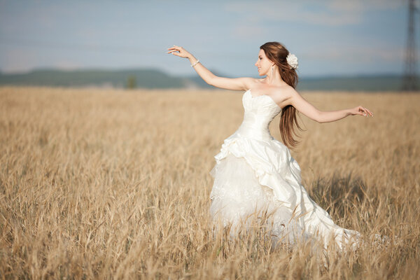 Beautiful bride at wedding day outdoor. Attractive newlywed woman in wedding dress. Portrait of bride.