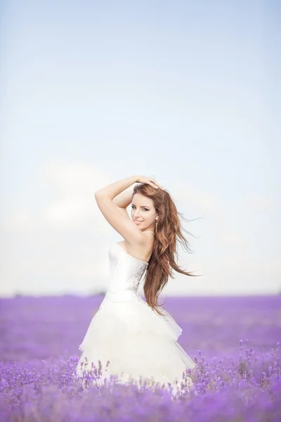 Bela noiva no dia do casamento no campo de lavanda — Fotografia de Stock