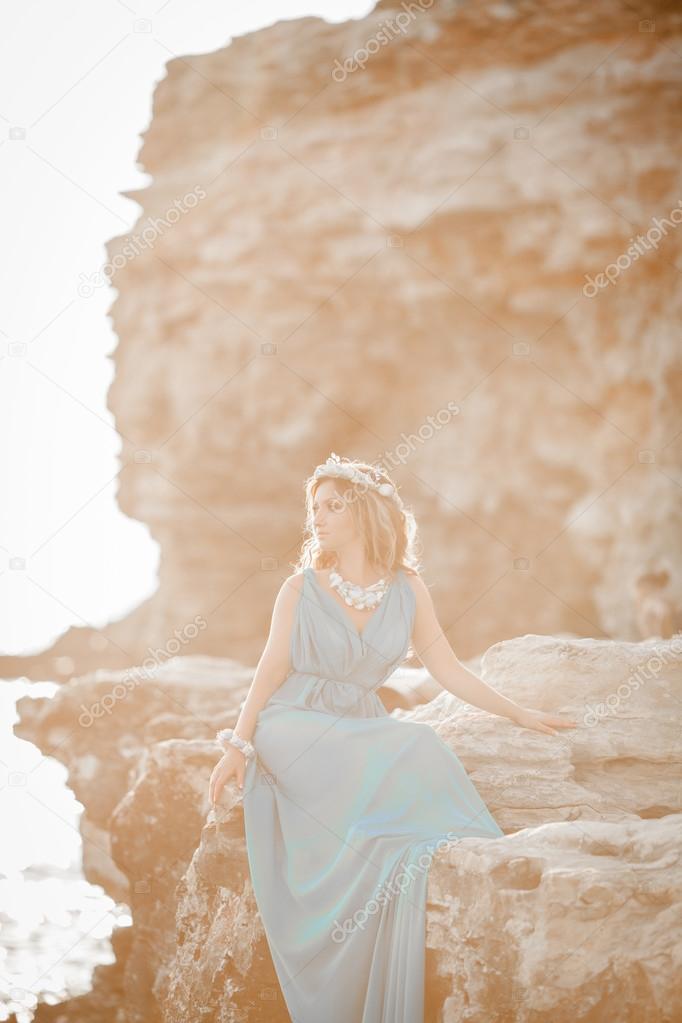 Beautiful Fantasy woman in long blue dress and seashell wreath