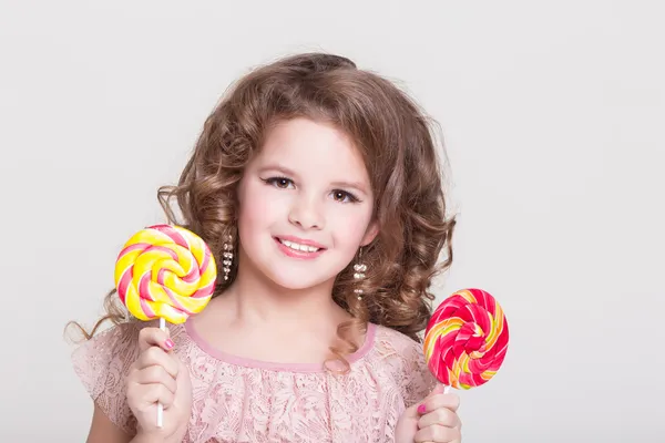 Αστείο παιδί με καραμέλα γλειφιτζούρι, ευτυχισμένη κοριτσάκι που τρώει μεγάλο ζάχαρη γλειφιτζούρι, παιδί τρώνε γλυκά. έκπληξη το παιδί με καραμέλα. — Φωτογραφία Αρχείου