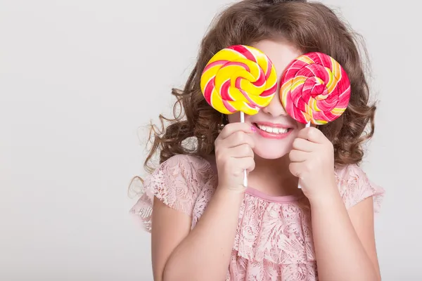 Забавна дитина з цукерками льодяник, щаслива маленька дівчинка, що їсть великий цукровий льодяник, дитина їсть цукерки. здивована дитина з цукерками . — стокове фото