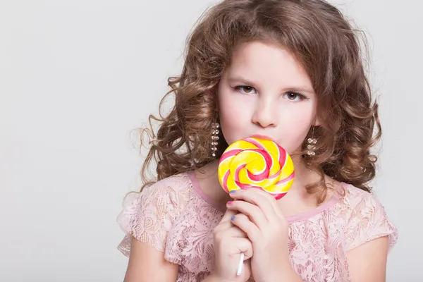 Funny child with candy lollipop, happy little girl eating big sugar lollipop, kid eat sweets. surprised child with candy. — Stock Photo, Image