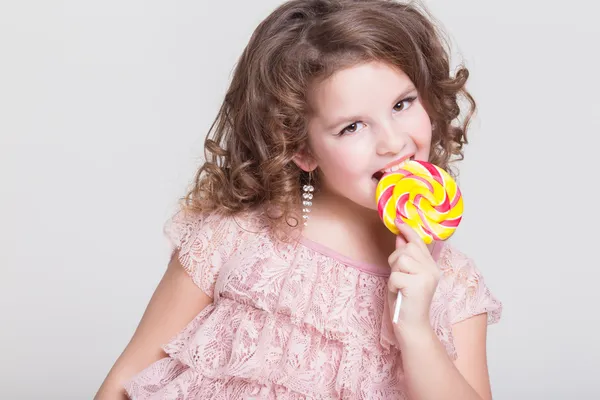 Funny child with candy lollipop, happy little girl eating big sugar lollipop, kid eat sweets. surprised child with candy. — Stock Photo, Image