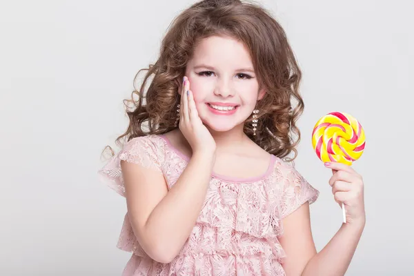 Funny child with candy lollipop, happy little girl eating big sugar lollipop, kid eat sweets. surprised child with candy. — Stock Photo, Image