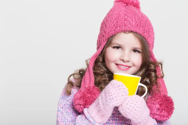 Beautiful child in winter hat drinking hot chocolate, little girl in woolen accessories with cup of tea or cocoa. — Stock Photo, Image