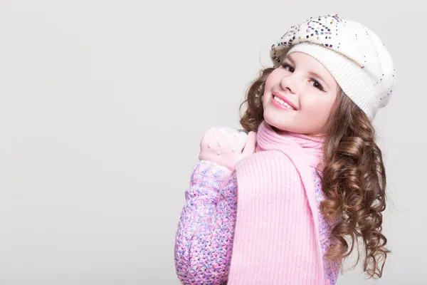 Joyeux petite fille en chapeau d'hiver et écharpe en laine ans pull coloré isolé . — Photo