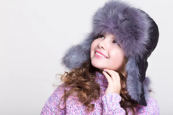 Mooie meisje in winter bont hoed en kleurrijke gezellige trui. — Stockfoto