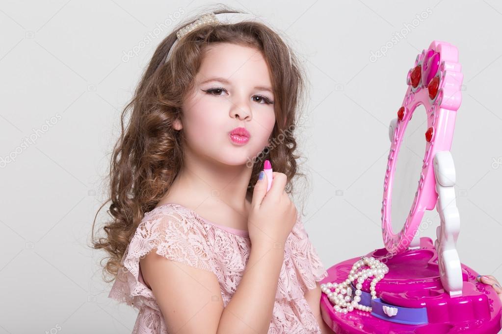 Cute little girl with toy mirror and lipstick. — Stock Photo © Armina