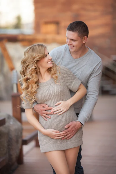 Young pregnant woman with husband walking outdoor and hugs tummy — Stock Photo, Image