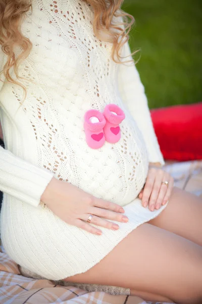 Mulher grávida barriga segurando botas de bebê rosa, esperando menina — Fotografia de Stock