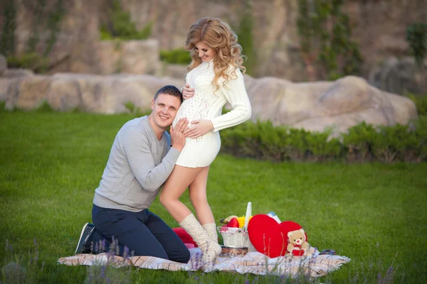 Pregnant woman and her husband relaxing on nature and have picnic in park — Stock Photo, Image