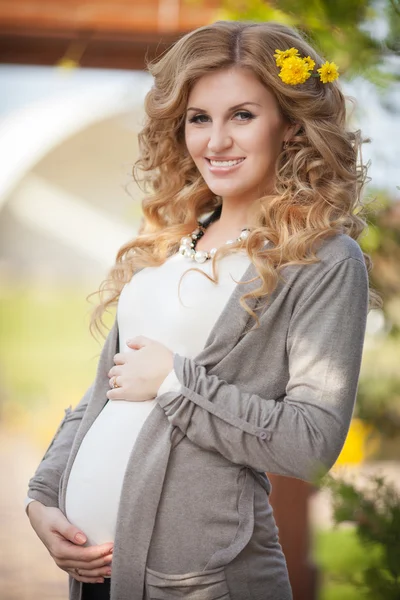 Happy young pregnant woman outdoors in spring green park — Stock Photo, Image