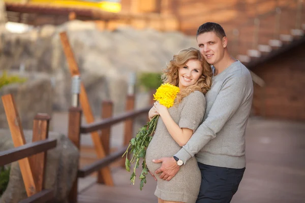 Young pregnant woman with husband walking outdoor and hugs tummy — Stock Photo, Image