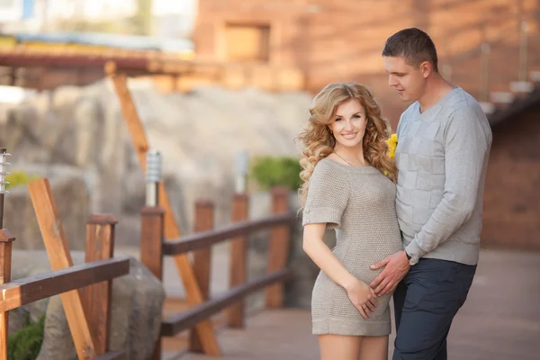 Young pregnant woman with husband walking outdoor and hugs tummy — Stock Photo, Image