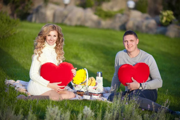 Zwangere vrouw en haar echtgenoot ontspannen op aard en hebben picknick in park — Stockfoto