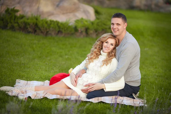 Gravid kvinna och hennes make avkopplande på natur och ha picknick i parken — Stockfoto