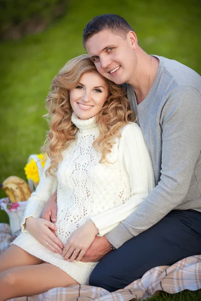 Pregnant woman and her husband relaxing on nature and have picnic in park — Stock Photo, Image