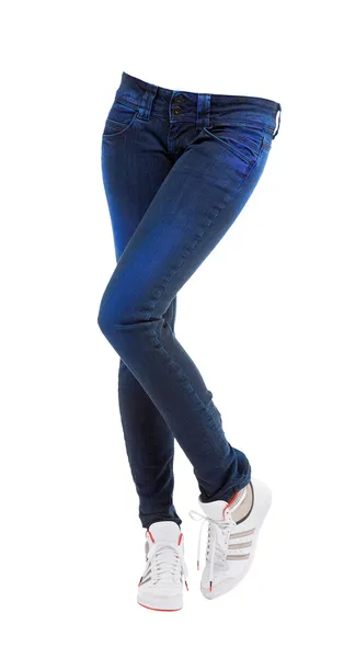 Ung kvinna korsade ben med färgade Blå jeans och sneakers — Stockfoto