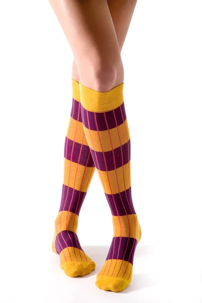 Jovem mulher cruzou as pernas posando com meias listradas amarelas — Fotografia de Stock