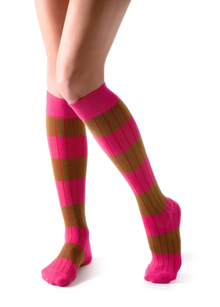 Молода жінка ноги позує з рожевими смугастими шкарпетками Стокова Картинка