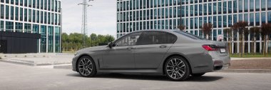 Gri BMW 740D xDrive modern ofis binalarının önünde. G12 model 340 HP motor, hızlanma 0-100 km-saat-5. Katowice, Polonya, 12.06.2021