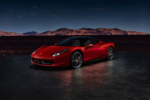 Çöl kumullarının önünde duran kırmızı bir Ferrari 458 Italia. Motor V8, 4.5L, 570HP. Fas manzaralı elektronik montaj. Katowice, Polonya, 23 / 12 / 2013