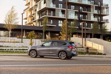 BMW X125, hibrit, fişe takılı araba, modern bir binanın yanına park edilmiş. İki motorun toplam gücü 220HP. Elektrik aralığı 52 km Katowice / Poland- 07.30.2021