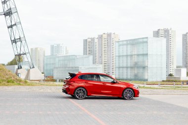 Silezya Müzesi 'nin önündeki kırmızı BMW M135i. Model F40, 2019 'dan üretildi. 306 HP motoru, ivme 0-100 km-saat - 4.8 s Katowice, Polonya, 09.16.2020