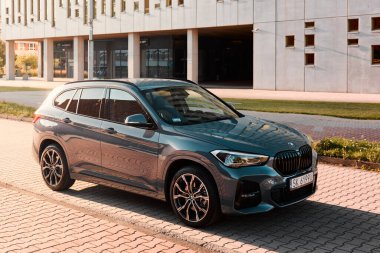 BMW X125, hibrit, fişe takılı araba, modern bir binanın yanına park edilmiş. İki motorun toplam gücü 220HP. Elektrik aralığı 52 km Katowice / Poland- 07.30.2021