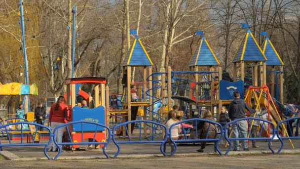Parque infantil y un montón de niños jugando — Vídeo de stock