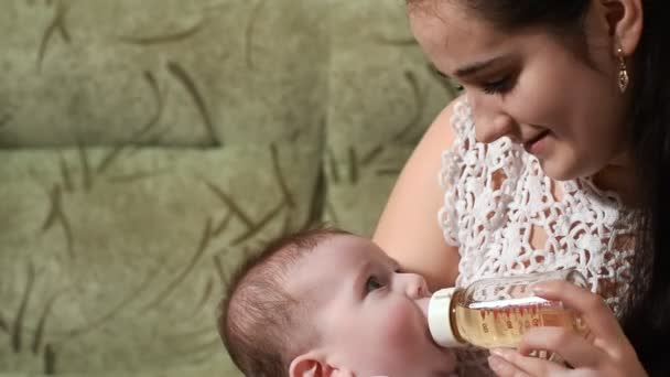 Мать кормит мальчика бутылочкой — стоковое видео