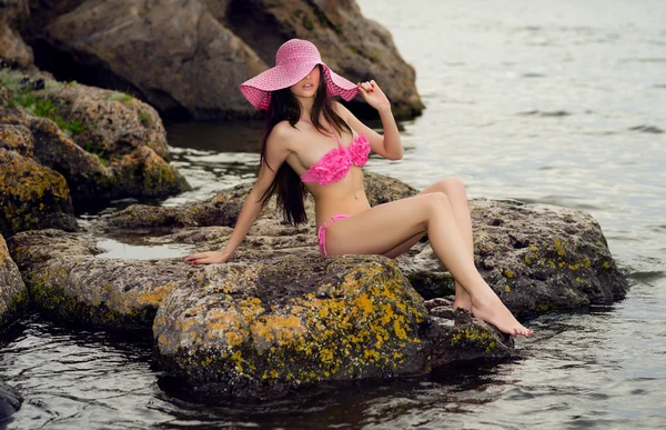 Young girl in a swimsuit on the rocks near the sea — Stock Photo, Image