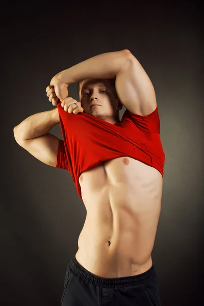 Здоровий м'язистий молодий чоловік позує в студії — стокове фото