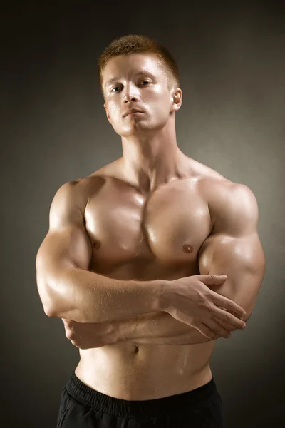 Gesunder muskulöser junger Mann posiert im Studio — Stockfoto