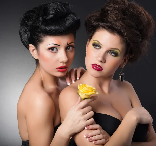 Portrait of two girls with flower in studio — Stock Photo, Image