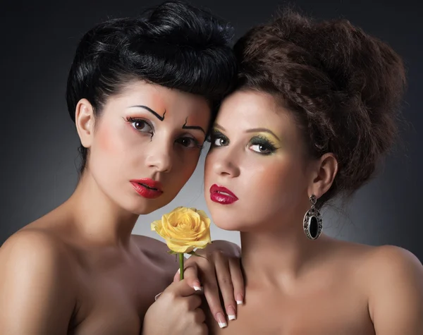 Ritratto di due ragazze con fiore in studio — Foto Stock