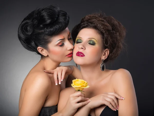 Portrait of two girls with flower in studio — Stock Photo, Image