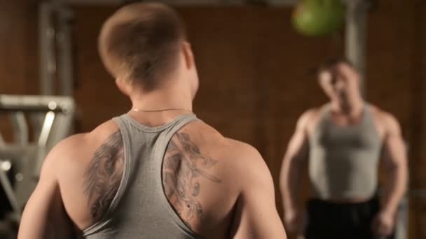 Здоровый мускулистый молодой человек позирует в студии — стоковое видео