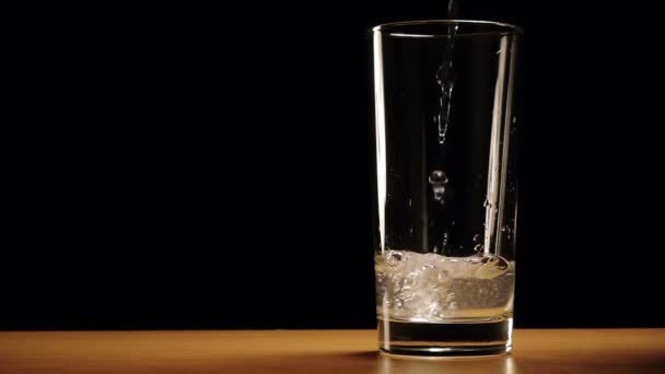 L'eau est lentement versée dans un verre 